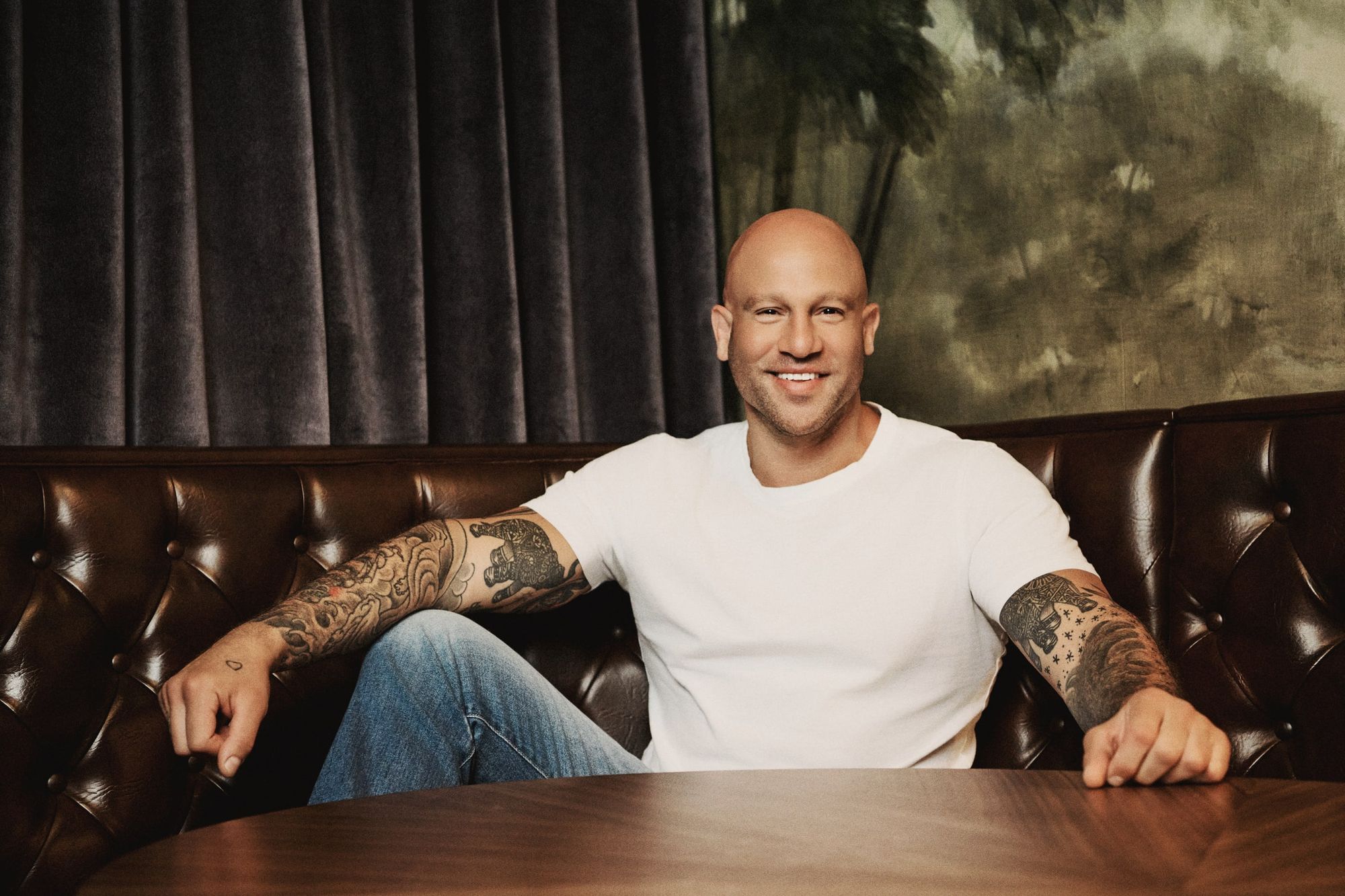 Jeff Halevy seated on a leather banquette, smiling