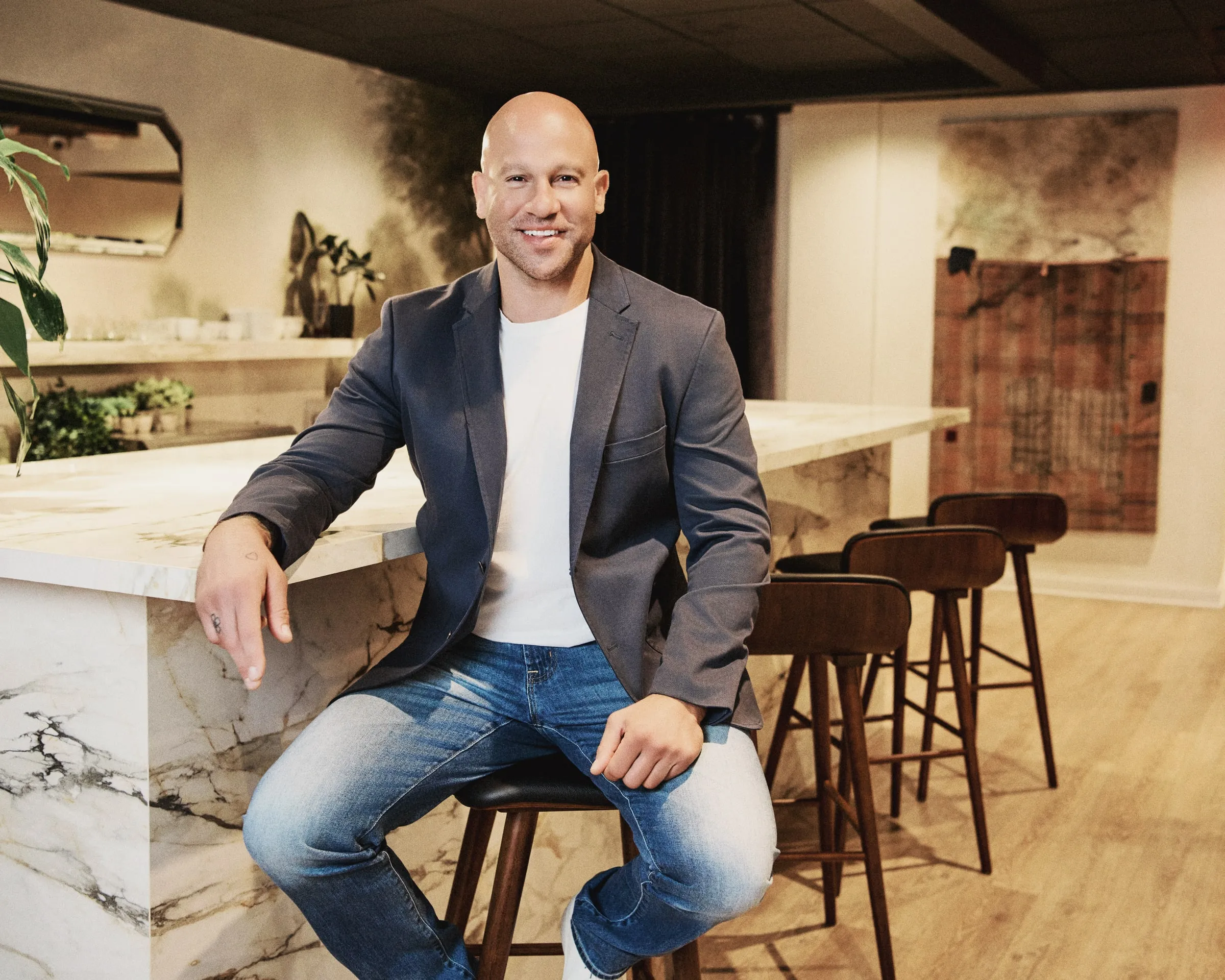 Jeff Halevy in a charcoal blazer, seated at a marble bar