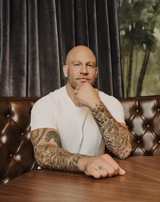 Jeff Halevy seated in a leather booth, chin resting on his fist