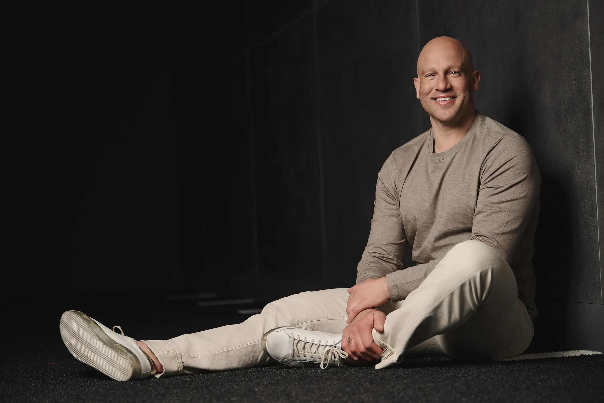 Jeff Halevy seated against a dark wall, smiling